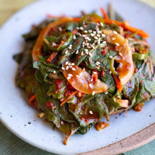 perilla kimchi on white plate with green and yellow place mat underneath