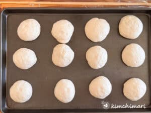 salt bread dough balls on dark pan