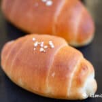 close up of salt bread on black baking pan